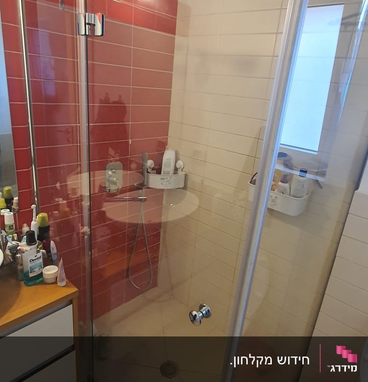 מקלחת עם דלת זכוכית, ראש מקלחת ומדף מוצרים